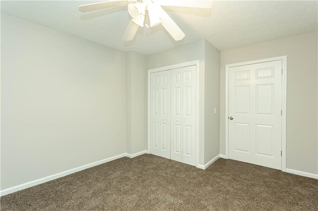 unfurnished bedroom with a closet, dark carpet, and ceiling fan