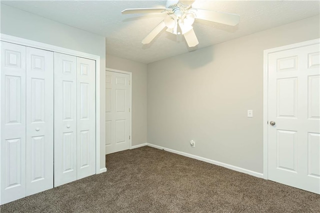 unfurnished bedroom featuring ceiling fan, dark colored carpet, and a closet