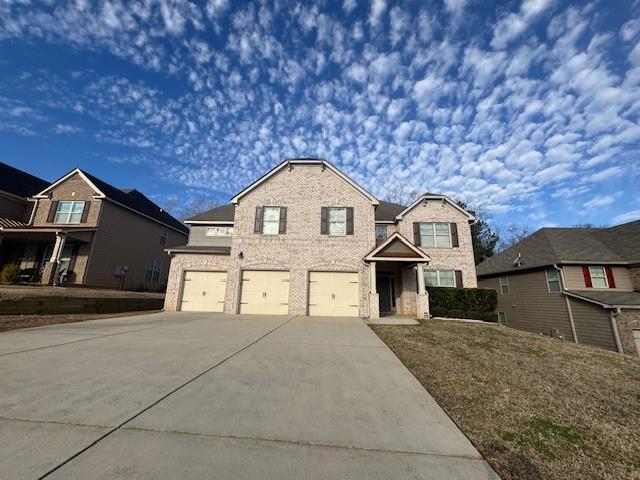 traditional-style home with brick siding, concrete driveway, and a garage