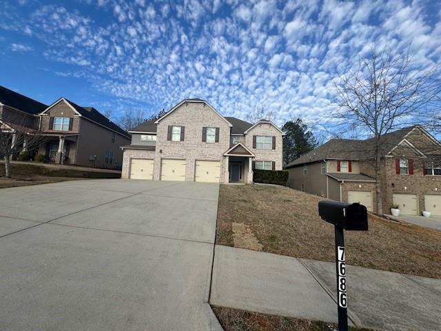 traditional-style house featuring concrete driveway and an attached garage