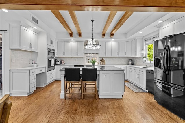 415 Southridge Rd, Winder, GA 30680 - kitchen featuring black fridge with ice dispenser, dishwasher, a center island, light wood-style floors, and white cabinets