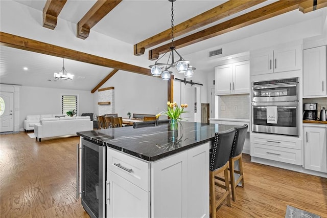 415 Southridge Rd, Winder, GA 30680 - kitchen with beverage cooler, a chandelier, double oven, white cabinetry, and beamed ceiling