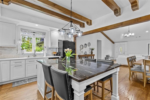 415 Southridge Rd, Winder, GA 30680 - kitchen featuring freestanding refrigerator, beamed ceiling, a breakfast bar, backsplash, and open floor plan