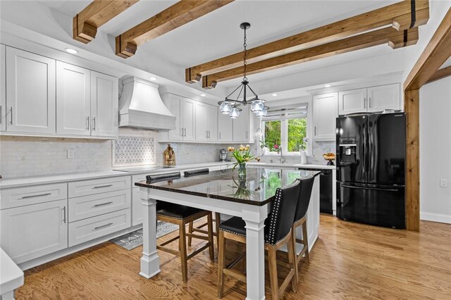 415 Southridge Rd, Winder, GA 30680 - kitchen featuring black appliances, premium range hood, a kitchen breakfast bar, beam ceiling, and white cabinets