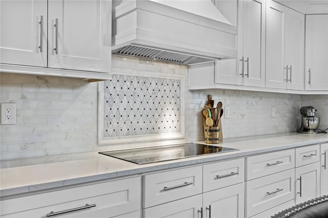 415 Southridge Rd, Winder, GA 30680 - kitchen with custom exhaust hood, black electric cooktop, white cabinets, and decorative backsplash