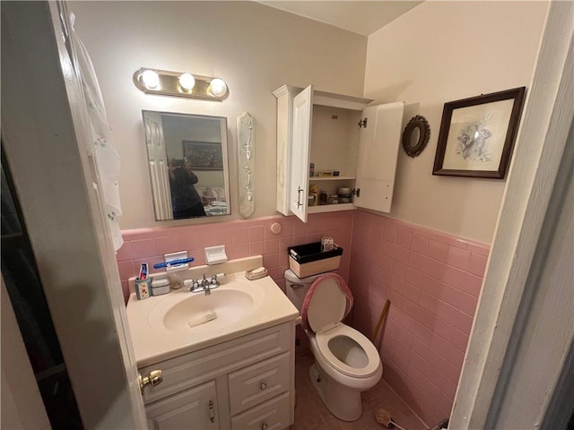 301 Sisson Ave NE, Atlanta, GA 30317 - bathroom featuring tile walls, vanity, wainscoting, and toilet