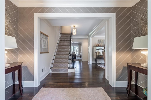 entrance foyer with ornamental molding, stairway, dark wood finished floors, and baseboards