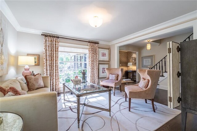 living area featuring ornamental molding, stairway, and wood finished floors