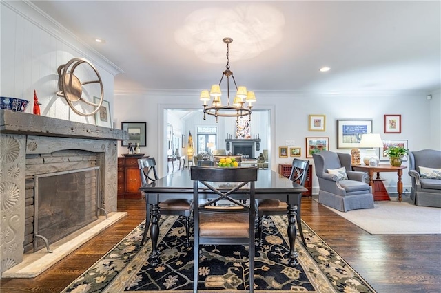 dining area with a fireplace, ornamental molding, and wood finished floors