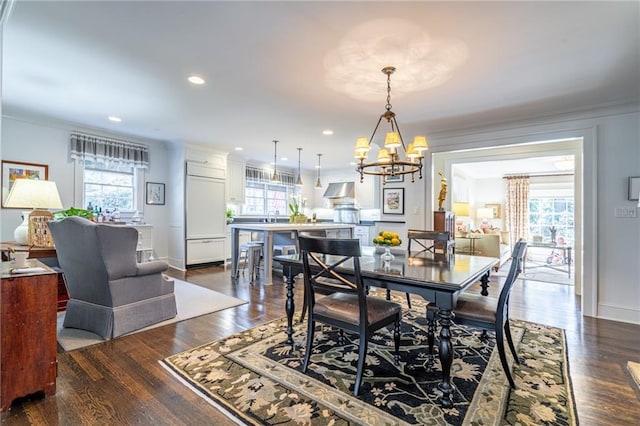 dining space featuring a notable chandelier, recessed lighting, baseboards, dark wood finished floors, and crown molding