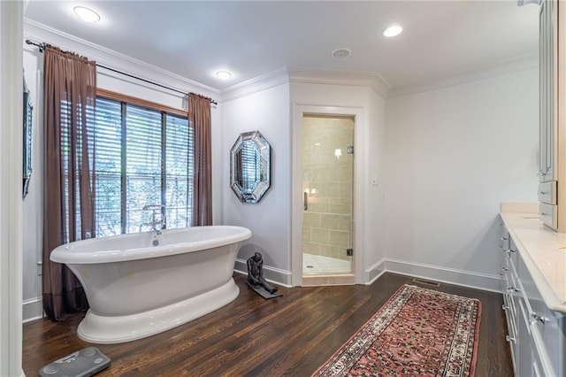 full bath with a stall shower, baseboards, crown molding, and wood finished floors