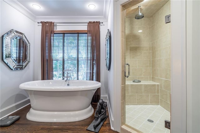 full bath featuring a freestanding bath, ornamental molding, a shower stall, wood finished floors, and baseboards