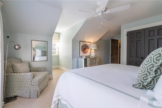 bedroom with light colored carpet, a ceiling fan, baseboards, vaulted ceiling, and a closet