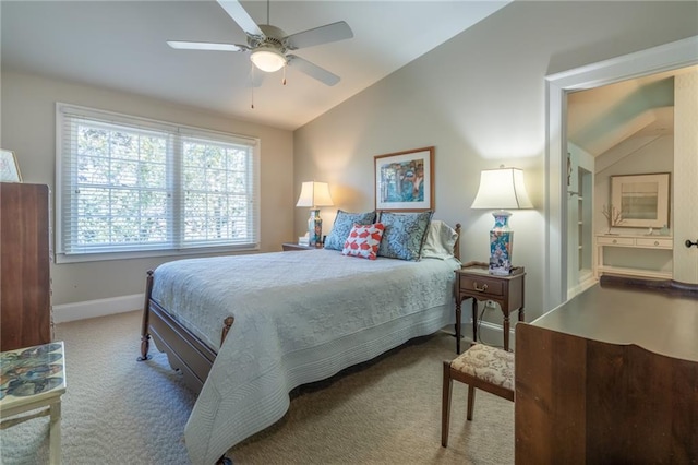 carpeted bedroom with a ceiling fan, vaulted ceiling, baseboards, and ensuite bathroom