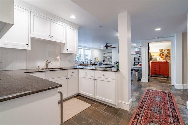 kitchen featuring ceiling fan, recessed lighting, a sink, white cabinets, and stone finish floor