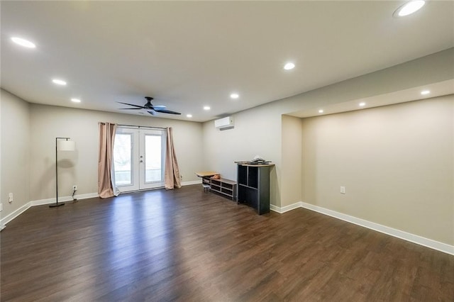 unfurnished living room with dark wood finished floors, a wall unit AC, recessed lighting, and baseboards