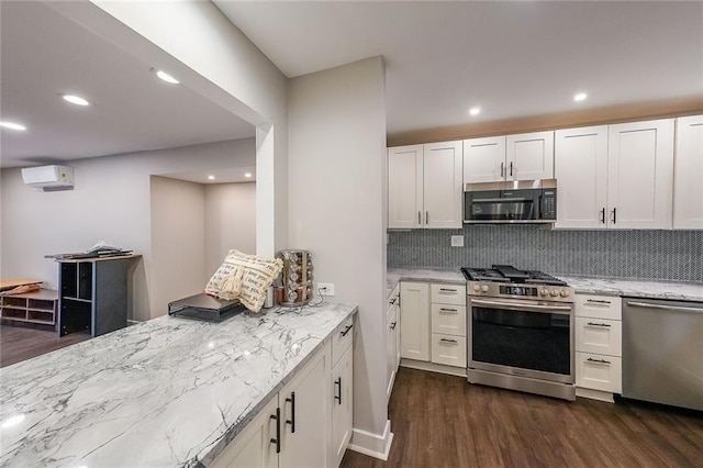 kitchen with light stone counters, dark wood-style flooring, appliances with stainless steel finishes, and a wall mounted AC