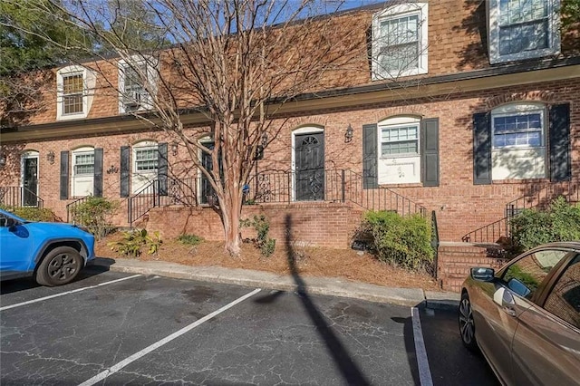 townhome / multi-family property featuring brick siding and uncovered parking