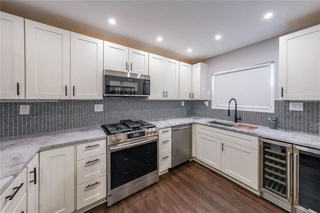 kitchen featuring a sink, stainless steel appliances, wine cooler, and white cabinets