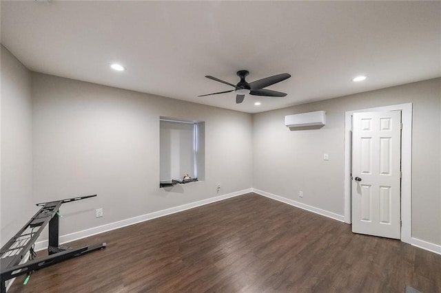 exercise area featuring dark wood finished floors, ceiling fan, baseboards, and a wall unit AC