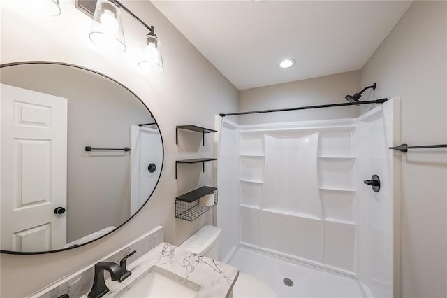 bathroom with a shower, toilet, and a sink