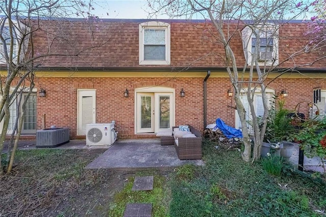 rear view of house with roof with shingles, ac unit, cooling unit, mansard roof, and a patio area