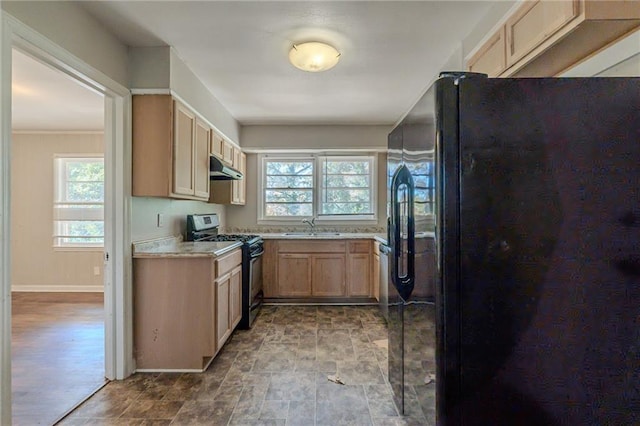 kitchen featuring light brown cabinetry, sink, a wealth of natural light, and black appliances