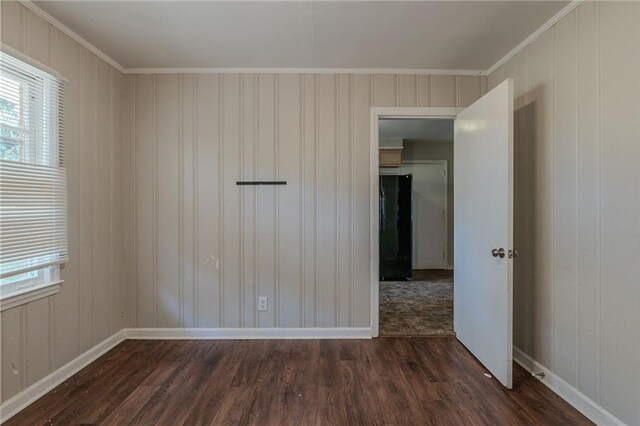 spare room featuring dark hardwood / wood-style floors and crown molding