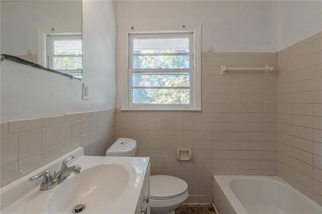 bathroom with plenty of natural light, tile walls, and vanity