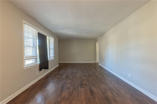 empty room with dark hardwood / wood-style flooring