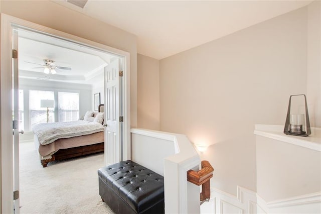 carpeted bedroom with a raised ceiling