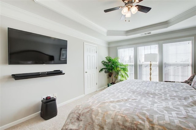 carpeted bedroom featuring ornamental molding, ceiling fan, and a tray ceiling