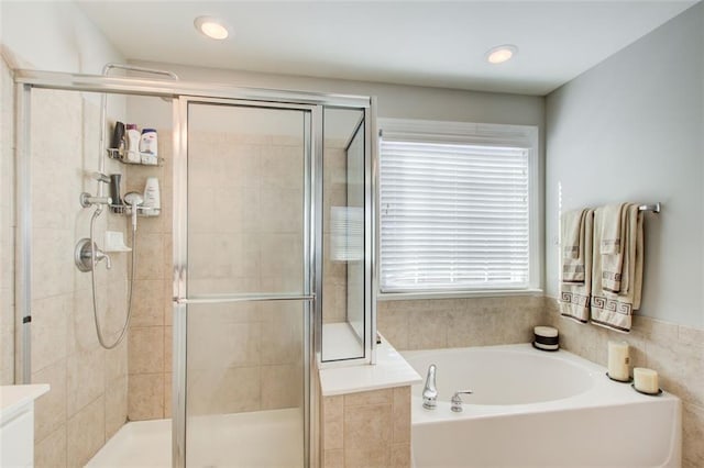 bathroom featuring shower with separate bathtub