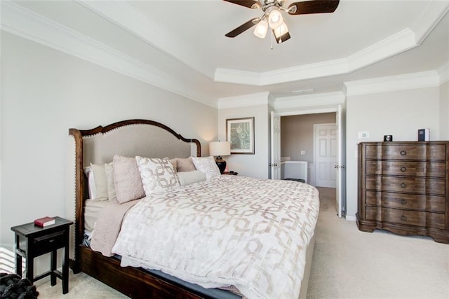 bedroom with crown molding, ceiling fan, a tray ceiling, and light carpet