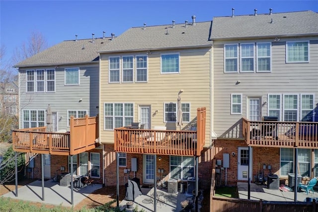 back of property with a wooden deck and a patio area