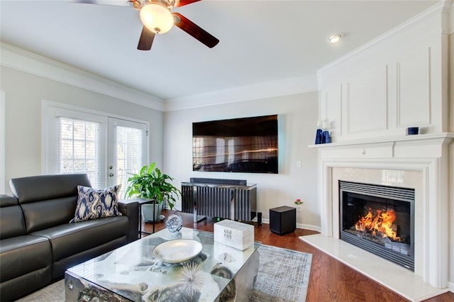 living room with ceiling fan, dark hardwood / wood-style floors, a high end fireplace, ornamental molding, and french doors