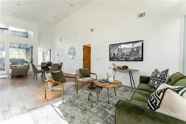 living room with light hardwood / wood-style flooring and a high ceiling