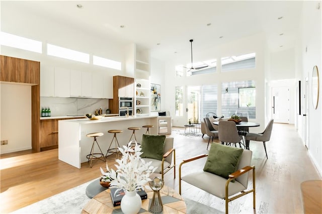 interior space with light hardwood / wood-style floors and a towering ceiling