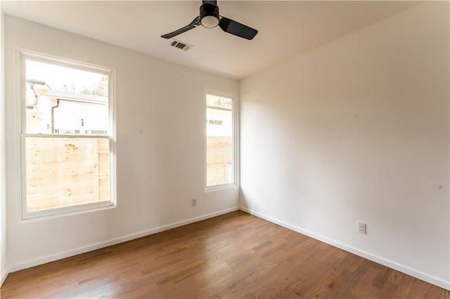 spare room featuring hardwood / wood-style floors, a healthy amount of sunlight, and ceiling fan