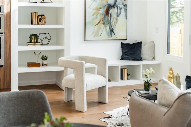 living area featuring built in features and light hardwood / wood-style flooring