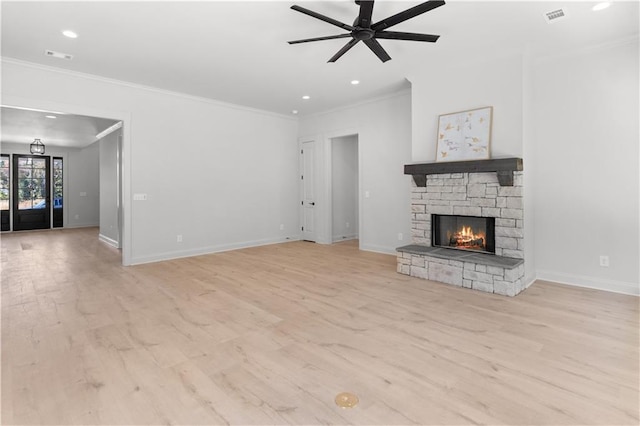 unfurnished living room featuring ceiling fan, light hardwood / wood-style floors, a stone fireplace, and ornamental molding