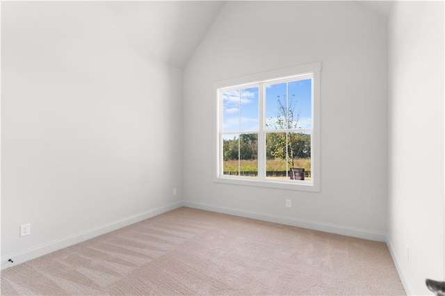 empty room featuring light carpet and vaulted ceiling