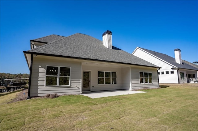 back of house with a lawn and a patio