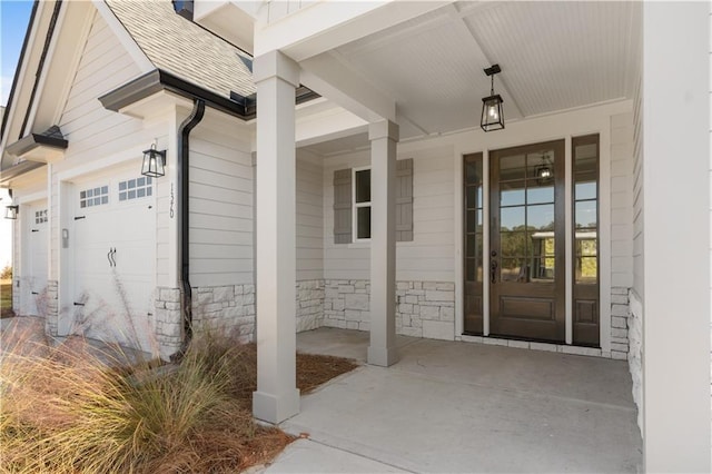 doorway to property with a porch and a garage