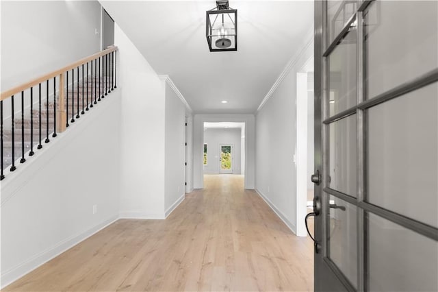 corridor with crown molding and light hardwood / wood-style floors