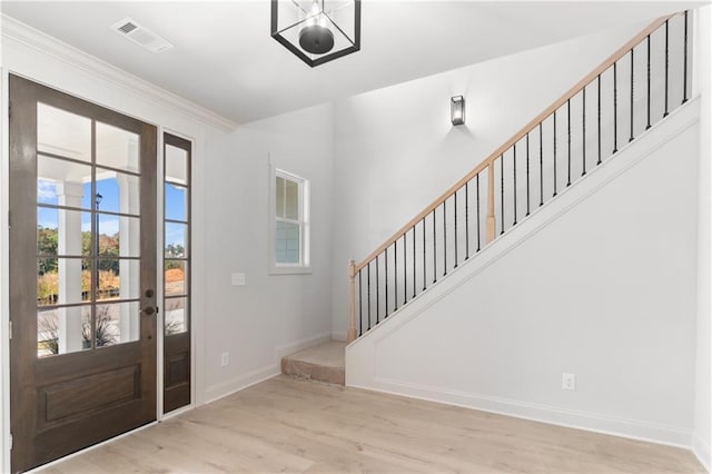 foyer featuring light hardwood / wood-style flooring and crown molding