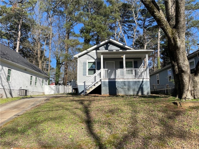 bungalow-style house with a porch, stairs, a front yard, and fence