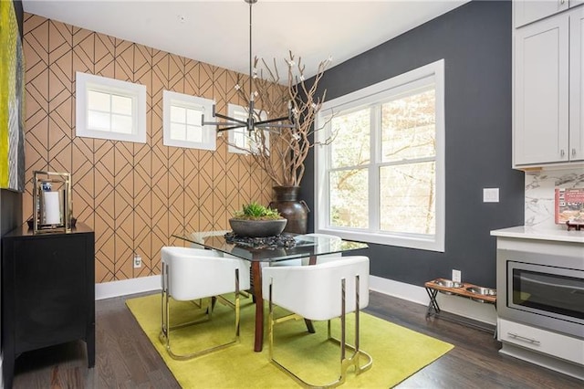 1821 Huntington Hills Ln NW, Atlanta, GA 30309 - dining area with an accent wall, baseboards, and dark wood-style flooring