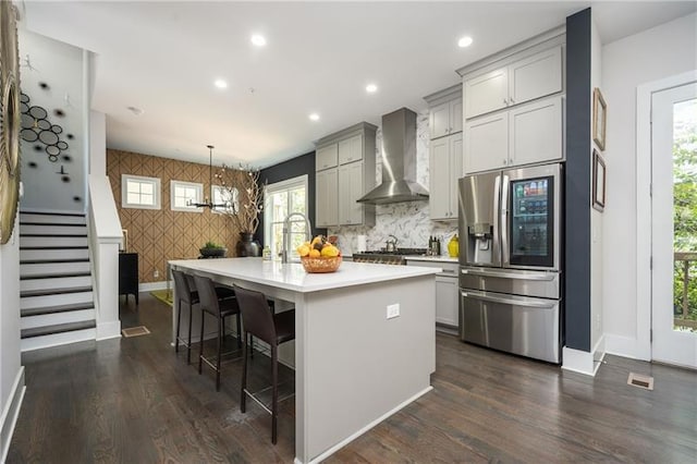 1821 Huntington Hills Ln NW, Atlanta, GA 30309 - kitchen with appliances with stainless steel finishes, wall chimney exhaust hood, baseboards, an accent wall, and light countertops