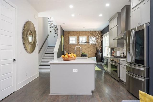 1821 Huntington Hills Ln NW, Atlanta, GA 30309 - kitchen featuring appliances with stainless steel finishes, an accent wall, wall chimney exhaust hood, baseboards, and wallpapered walls